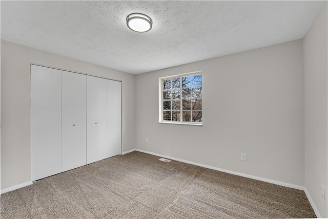 3414 Dearwood Dr SW, Lilburn, GA 30047 - unfurnished bedroom featuring a closet, carpet floors, baseboards, and a textured ceiling