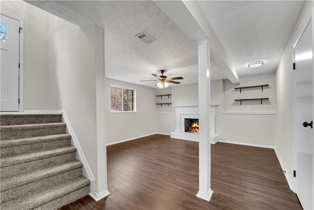 3414 Dearwood Dr SW, Lilburn, GA 30047 - unfurnished living room with a textured ceiling, ceiling fan, stairway, dark wood-style floors, and a fireplace