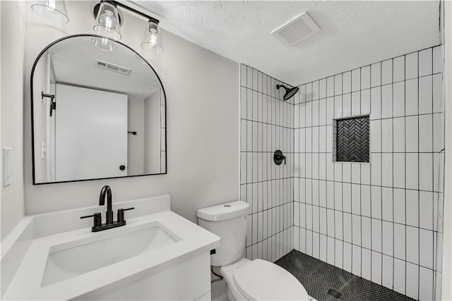3414 Dearwood Dr SW, Lilburn, GA 30047 - bathroom featuring toilet, tiled shower, vanity, and a textured ceiling