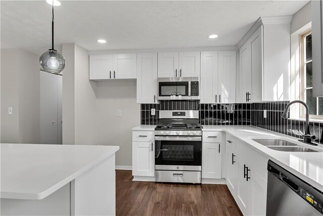 3414 Dearwood Dr SW, Lilburn, GA 30047 - kitchen with appliances with stainless steel finishes, decorative backsplash, a center island, dark wood-style flooring, and white cabinetry
