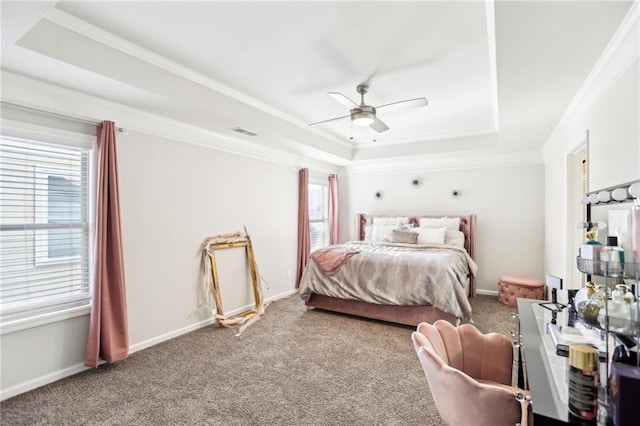 bedroom featuring carpet floors, ceiling fan, a tray ceiling, and multiple windows