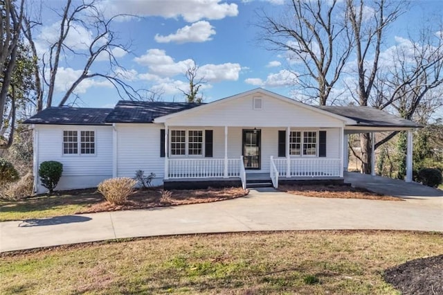 view of front of property with covered porch, concrete driveway, and a carport