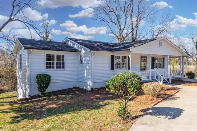 view of front of house featuring covered porch, concrete driveway, and a front yard