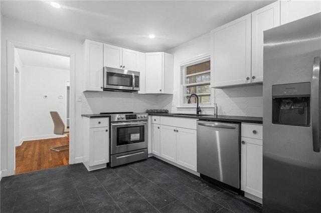 kitchen with white cabinets, backsplash, sink, and stainless steel appliances