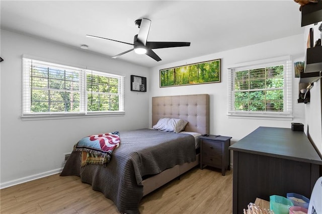 bedroom featuring light wood-style floors, a ceiling fan, and baseboards