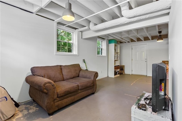 living area with concrete floors and beam ceiling