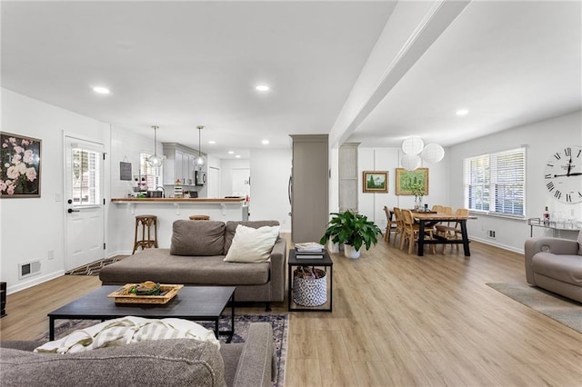 living room with baseboards, recessed lighting, light wood-style floors, and visible vents