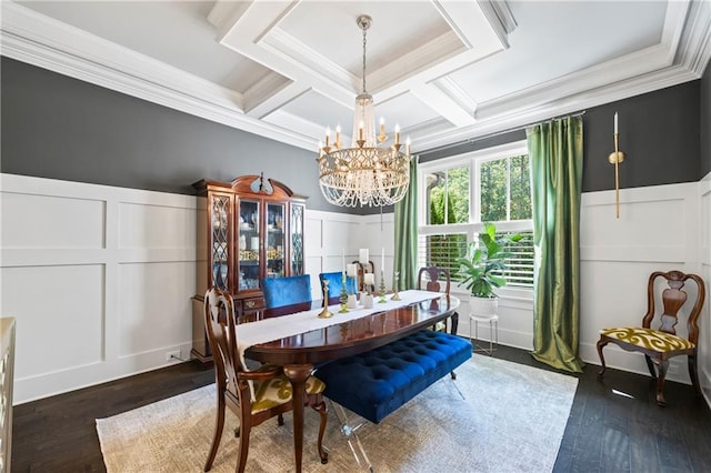 dining room with coffered ceiling, dark wood-style floors, crown molding, a chandelier, and a decorative wall