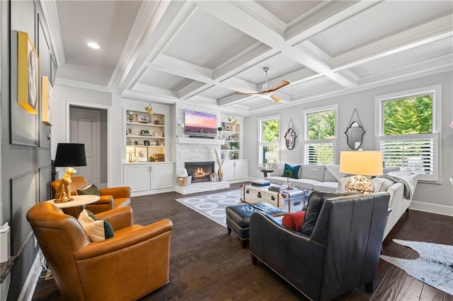 living area featuring dark wood-style floors, beam ceiling, coffered ceiling, and a stone fireplace