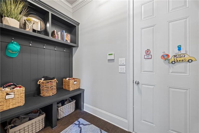 mudroom with dark wood-style floors, crown molding, and baseboards