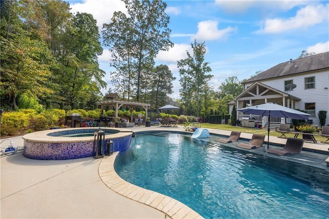 view of pool with a patio area, a pool with connected hot tub, and a pergola