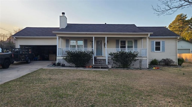 ranch-style home featuring covered porch, a yard, and an attached garage