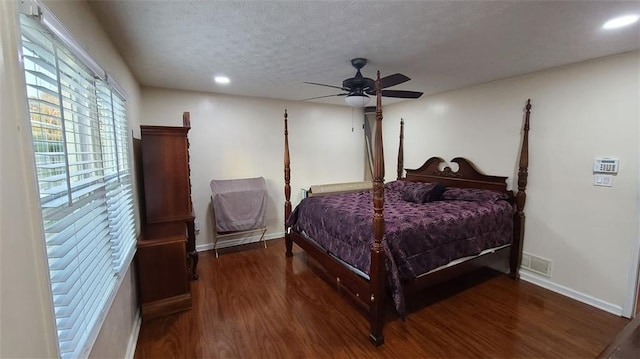 bedroom with dark wood-style flooring, ceiling fan, a textured ceiling, and baseboards