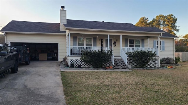 single story home featuring a porch, concrete driveway, an attached garage, and a front lawn