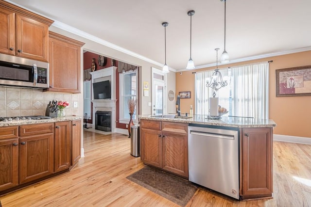 1765 Dew Pl, Marietta, GA 30064 - kitchen with appliances with stainless steel finishes, a sink, brown cabinets, light wood-style floors, and crown molding