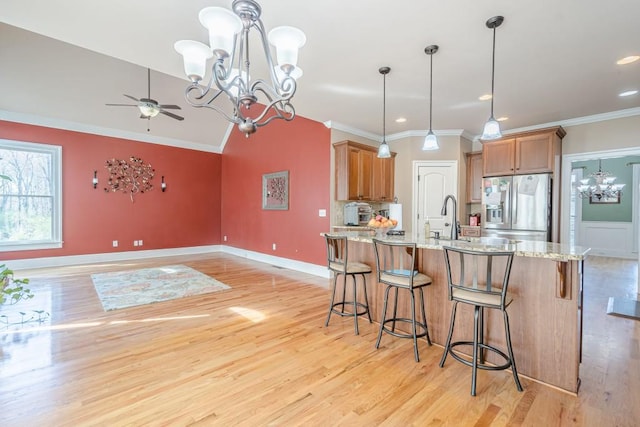 1765 Dew Pl, Marietta, GA 30064 - kitchen featuring stainless steel refrigerator with ice dispenser, a chandelier, ornamental molding, brown cabinetry, and light stone countertops