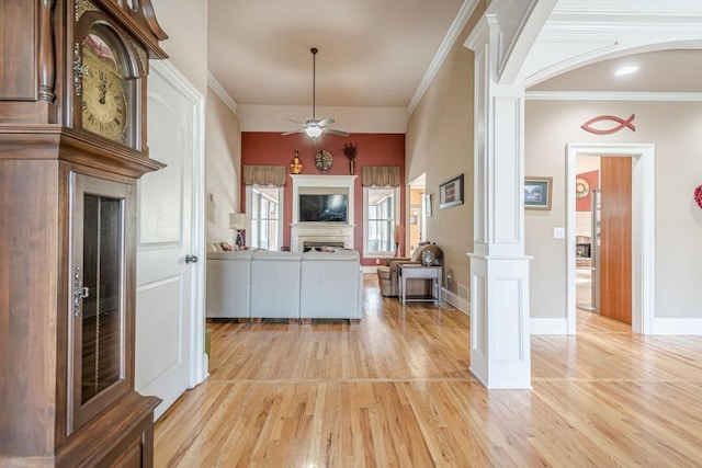 1765 Dew Pl, Marietta, GA 30064 - kitchen featuring ornate columns, light wood-type flooring, ceiling fan, a fireplace, and crown molding