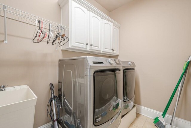 1765 Dew Pl, Marietta, GA 30064 - laundry room with washing machine and clothes dryer, cabinet space, baseboards, and light tile patterned floors