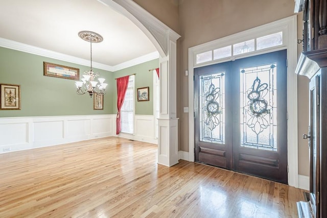 1765 Dew Pl, Marietta, GA 30064 - entrance foyer with french doors, arched walkways, light wood-type flooring, a wainscoted wall, and ornamental molding