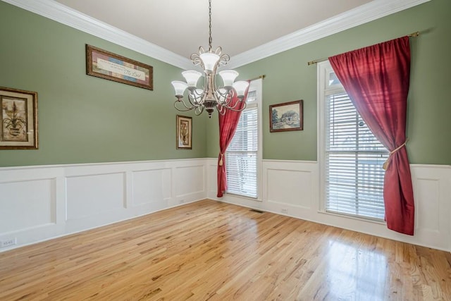 1765 Dew Pl, Marietta, GA 30064 - unfurnished dining area with a chandelier, crown molding, wainscoting, wood finished floors, and a decorative wall