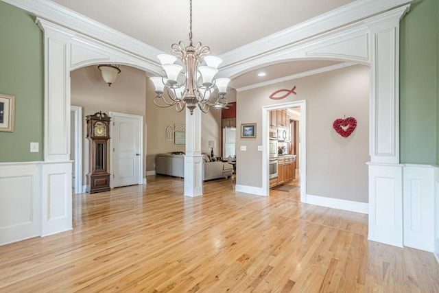 1765 Dew Pl, Marietta, GA 30064 - spare room featuring arched walkways, a chandelier, light wood-style floors, ornamental molding, and baseboards