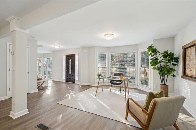 living room with hardwood / wood-style flooring, sink, and decorative columns