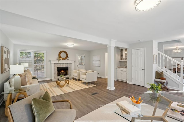 living room with dark wood-type flooring, a premium fireplace, and a wealth of natural light