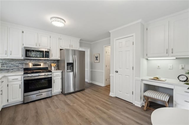 kitchen featuring tasteful backsplash, white cabinets, and stainless steel appliances