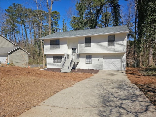 split foyer home with concrete driveway and an attached garage