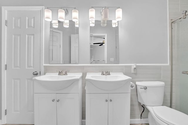bathroom with vanity, ceiling fan, toilet, and an enclosed shower