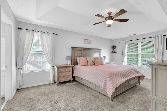 bedroom featuring baseboards, light carpet, and multiple windows