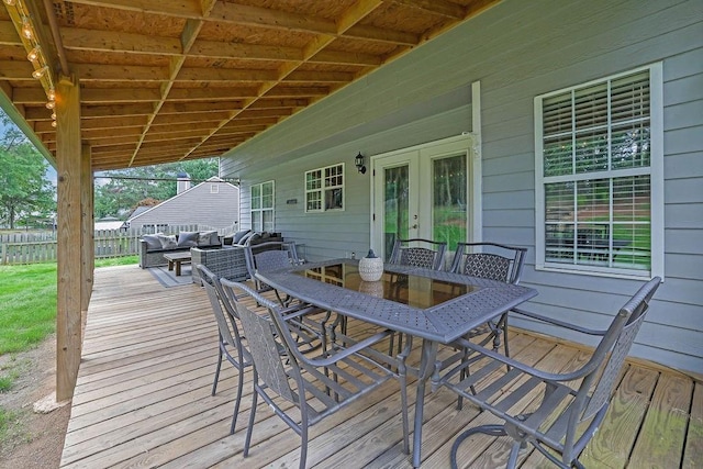 wooden terrace with french doors, outdoor dining area, fence, and outdoor lounge area
