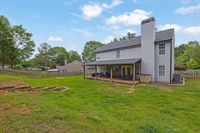 rear view of property featuring a wooden deck, central AC unit, a shingled roof, a chimney, and a vegetable garden