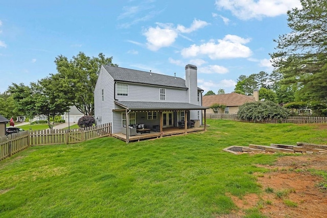 back of house with a wooden deck, a chimney, and a shingled roof