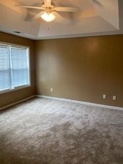 spare room with ceiling fan, carpet, and a raised ceiling