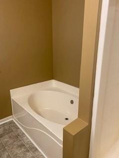 bathroom with tile patterned floors and a bathing tub