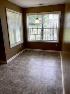 unfurnished dining area featuring tile patterned flooring and a healthy amount of sunlight