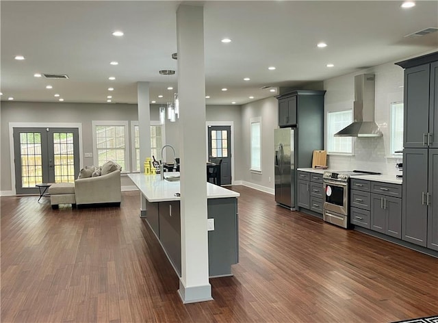 1255 Plaza Ave SW, Atlanta, GA 30310 - kitchen featuring wall chimney range hood, stainless steel appliances, open floor plan, gray cabinets, and light countertops