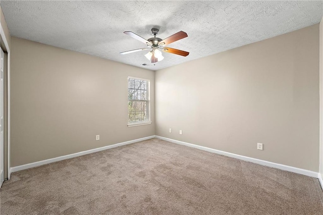 carpeted spare room with ceiling fan, a textured ceiling, visible vents, and baseboards