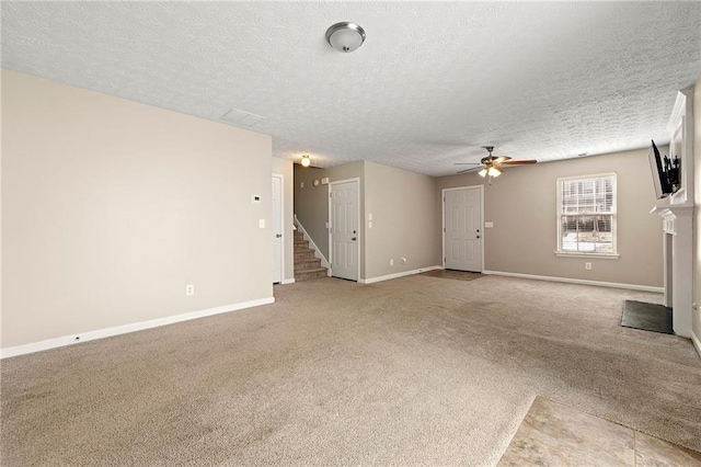 unfurnished living room featuring a fireplace with flush hearth, stairway, carpet flooring, and baseboards