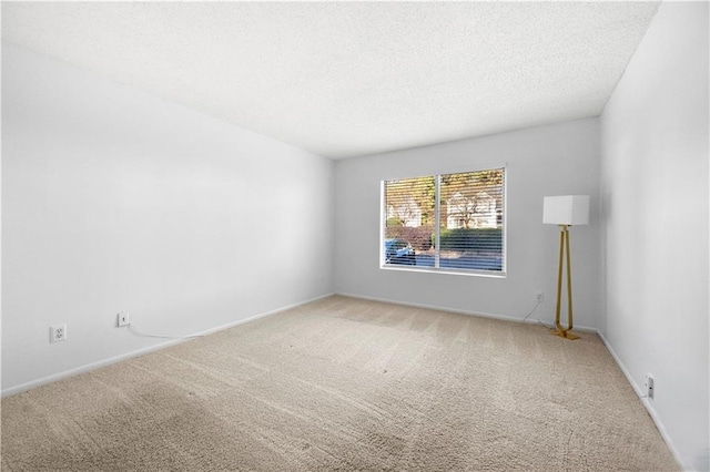 carpeted empty room featuring a textured ceiling