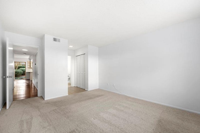 unfurnished bedroom with light carpet and a closet