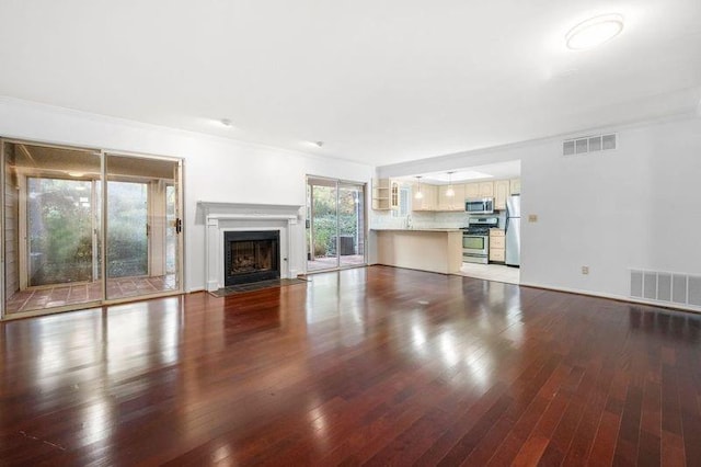 unfurnished living room featuring hardwood / wood-style floors and crown molding