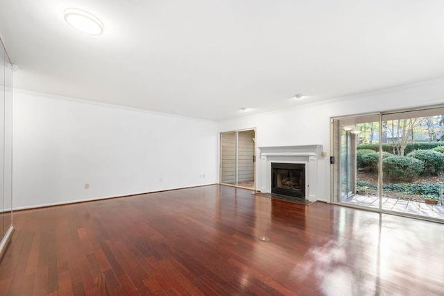 unfurnished living room with crown molding and dark hardwood / wood-style floors