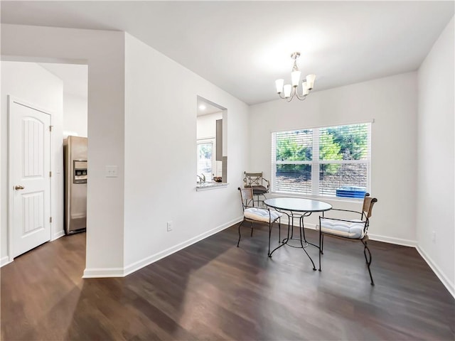 dining room with dark wood-type flooring and a chandelier