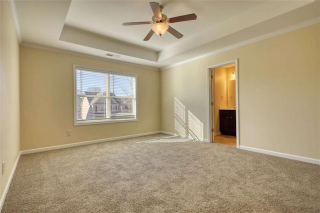 unfurnished room featuring baseboards, visible vents, a tray ceiling, crown molding, and carpet floors