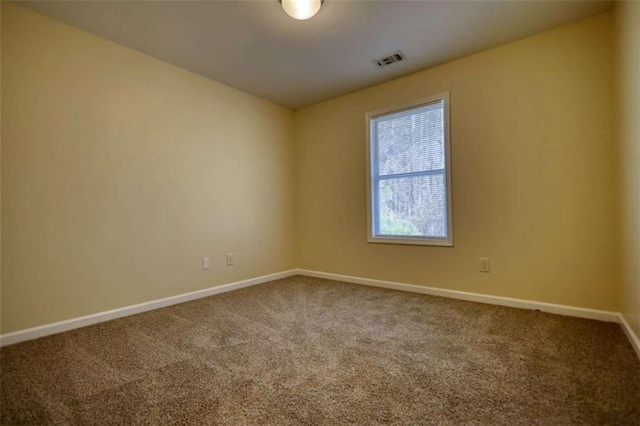 carpeted empty room featuring visible vents and baseboards