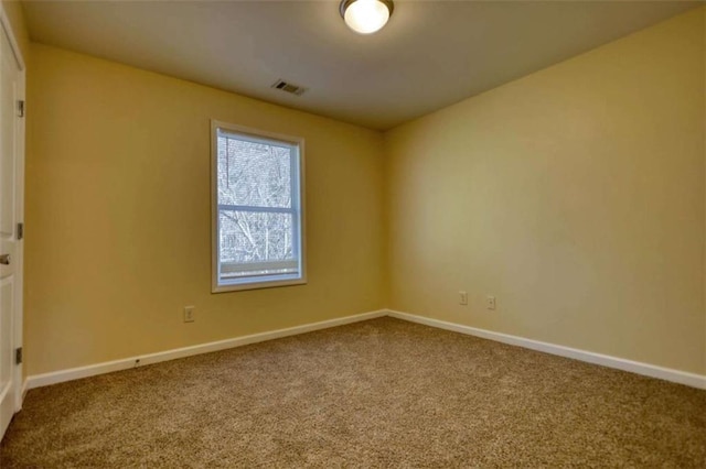 carpeted empty room featuring visible vents and baseboards