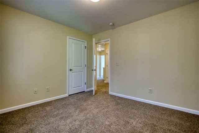 empty room with carpet flooring and baseboards