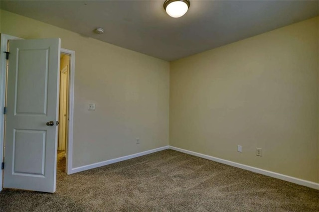 carpeted spare room featuring baseboards